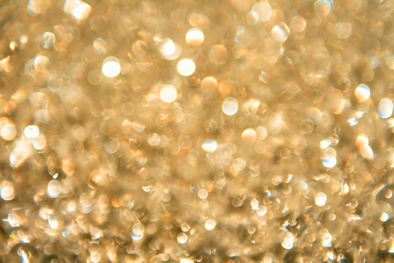 Goldener Glitter in der Nahaufnahme, oder sind es Wassertropfen?